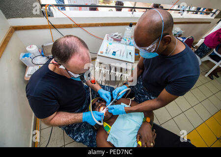 150803-N-NK 134-069 PORTSMOUTH, Dominica (Aug. 3, 2015) - Lt.Cmdr. James Ward, ein Eingeborener von Las Vegas, Nev und Zahnarzt zu U.S. Naval Hospital Neapel, Italien zugewiesen, Links, und Hospital Corpsman 3. Klasse Ralph Hawker, ein Eingeborener von Houston, Texas, zu Naval Hospital Beaufort, S.C. zugeordnet wird, führen Sie einen zahnmedizinischen Verfahren auf einem Patienten an einer medizinischen Website an der Roosevelt Douglas Grundschule zur Unterstützung der Fortsetzung Versprechen 2015 gegründet. Weiterhin Versprechen ist ein US Southern Command - gefördert und U.S. Naval Forces Southern Command/USA Flotte - durchgeführt, um die Bereitstellung zu zivil-militärischen Oper Verhalten Stockfoto