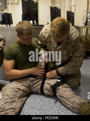 Lance Cpl. Nathan Lynch, ein schweres Gerät-Operator, mit dem Engineer Detachment, Bekämpfung von Logistik-Bataillon 26, 26. Marine Expeditionary Unit (MEU), gilt ein Druckverband um ein mock massive Blutung Verletzungen auf einem simulierten Unfall während einer Bekämpfung Life Saver an Bord der USS Arlington (LPD 24) 1. August 2015 zu stoppen. Marines mit dem 26. MEU und Matrosen mit der Kearsarge amphibische bereit Gruppe beteiligt sind in Composite Training Unit Übung (COMPTUEX) in Vorbereitung auf ihre baldige Entsendung zu den 5. und 6. Flotte Verantwortung später im Herbst. (USA-Marin Stockfoto