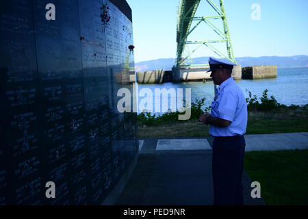 Chief Petty Officer Christopher Sheppard, Offizier, Aids zur Navigation Team Astoria, Erz, schaut auf eine Mauer der Erinnerung an die maritime Memorial Park in Astoria nach der Gedenkfeier des jährlichen Seaman, Aug 7, 2015. Sheppard hat ein Familienname auf der Wand, die er auf der Suche nach während einer Hommage an die anderen Namen war. (U.S. Coast Guard Foto von Petty Officer 1st Class Levi lesen) Stockfoto