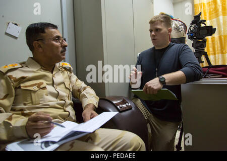 Us-Armee Sgt. William Reinier (rechts), ein Fallschirmjäger zu Combined Joint Force Land Component Command, Irak, Public Affairs Office zugewiesen wird, schildert ein Reporter während einer post-Befehl Übung im Camp Taji, Irak, Aug 4, 2015. Durch beraten und unterstützen und der Aufbau der Kapazitäten Missionen, die Combined Joint Task Force - Betrieb die Lösung der multinationale Koalition hat mehr als 11.000 irakische Sicherheitskräfte der Islamischen Staat im Irak und der Levante zu besiegen ausgebildet. (U.S. Armee Foto von Sgt. Charles M. Bailey/Freigegeben) Stockfoto