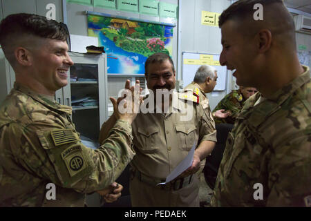 Us-Armee Kapitän Seth Smith (links), ein Fallschirmjäger zu Hauptsitz und Sitz Truppe, 5.Staffel, 73 Cavalry Regiment zugeordnet, 3. Brigade, 82nd Airborne Division, gibt eine Fünf zu irakischen Armee Brig. Gen Naseer (Mitte) während einer post-Befehl Übung im Camp Taji, Irak, Aug 4, 2015. Durch beraten und unterstützen und der Aufbau der Kapazitäten Missionen, die Combined Joint Task Force - Betrieb die Lösung der multinationale Koalition hat mehr als 11.000 irakische Sicherheitskräfte der Islamischen Staat im Irak und der Levante zu besiegen ausgebildet. (U.S. Armee Foto von Sgt. Charles M. Bailey Stockfoto