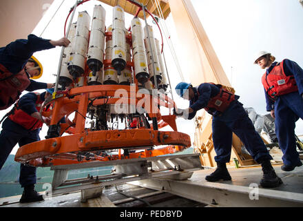 Besatzungsmitglieder an Bord Coast Guard Cutter Healy helfen ein Gerät entwickelt, Wasserproben zu entnehmen und eine Vielzahl von wissenschaftlichen Tests in den Arktischen Ozean Aug 8, 2015, vor dem Erhalten unterwegs für die Geotraces Mission testen. Geotraces ist Healys zweite Science Mission des Sommers, und ist eine internationale Anstrengungen zur Verteilung von Spurenelementen in den Weltmeeren zu studieren, mit einem Schwerpunkt auf den Arktischen Ozean. (U.S. Coast Guard Foto von Petty Officer 2. Klasse Cory J. Mendenhall) Stockfoto