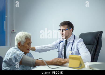 Arzt führt eine körperliche Untersuchung der älteren Menschen in der Klinik oder medizinische Einheit. Stockfoto