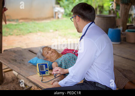 Arzt oder medizinischen Freiwillige, die ältere Menschen im ländlichen Asien besuchen. Stockfoto
