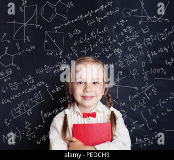 Kinder mathematische Bildung Konzept. Gerne kleine Mädchen mathe Student auf Schule blackboard Hintergrund mit handzeichnungen Wissenschaft Formel Muster Stockfoto