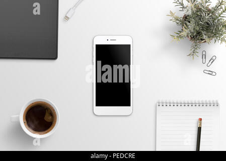 Flach Szene mit weißen smart phone Mockup auf Büro Schreibtisch. Ordner, pen, pad, Pflanze, Kaffee neben. Stockfoto