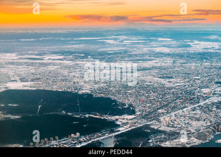 Riga, Lettland. Luftaufnahme von Sonnenaufgang über der Stadt. Blick aus grosser Höhe Flug von Flugzeugen auf der lettischen Hauptstadt im Winter bei Sonnenaufgang. Stockfoto