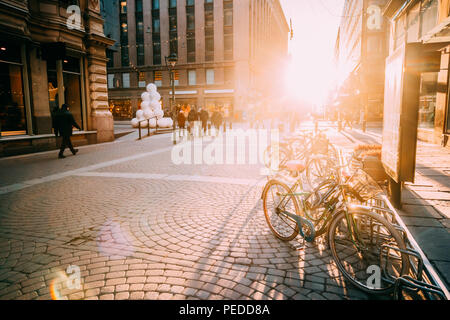 Helsinki, Finnland. Fahrräder in der Nähe von Läden in Kluuvikatu Straße geparkt. Ausblick auf die Straße im Sonnenlicht Dekoration für Weihnachten und Neujahr Urlaub. Stockfoto