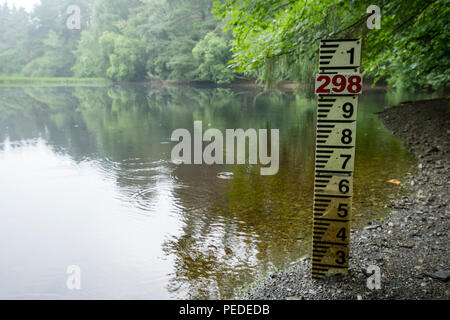 Regentropfen Ringe auf der niedrigen Wasserstand in einem kleinen See, der wegen einer längeren Bann des heißen Wetters in Großbritannien. Stockfoto