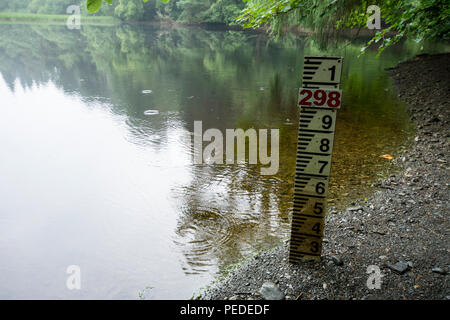 Regentropfen Ringe auf der niedrigen Wasserstand in einem kleinen See, der wegen einer längeren Bann des heißen Wetters in Großbritannien. Stockfoto