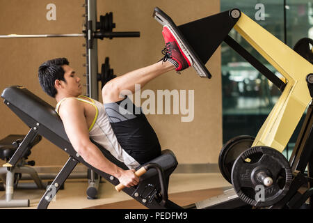 Junge Mann an der Beinpresse trainieren während der unteren Körper Workout Stockfoto