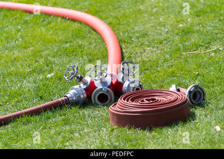 Mehrere rote Feuerlöschschläuchen mit Stecker Stück Stockfoto