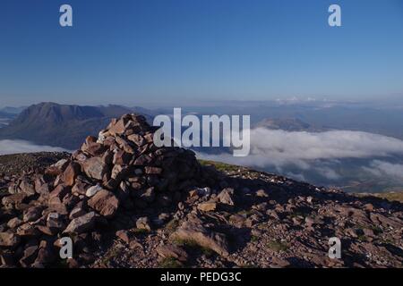 Berg Cairn auf dem Gipfel des Meall aGhiubhais oben eine leichte Wolke Inversion. Beinn Eighe, Torridon, Schottland, Großbritannien. Stockfoto