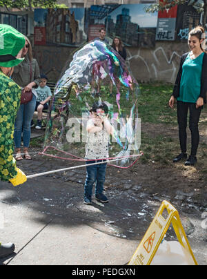 Kleiner Junge in einer riesigen Blase durch Freakbubbles, Edinburgh Festival Fringe outdoor Performer in der Mitte der Wiese Weg, im Zentrum der Stadt abgedeckt. Stockfoto