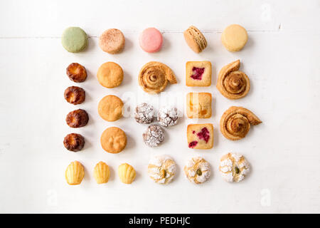 Eine spielerische Auswahl an Kuchen und Gebäck in Muster und auf weißem Hintergrund Stockfoto