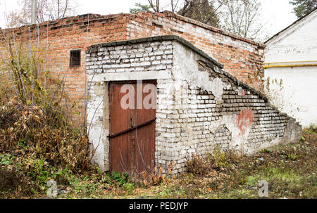 Alten, verlassenen Keller mit einem roten Tür Stockfoto
