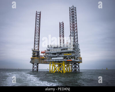 Die Atlantic Amsterdam aufgebockt neben das erste Rennen Bank Offshore-Windpark (ROW01-Z02) Umspannwerk. Stockfoto