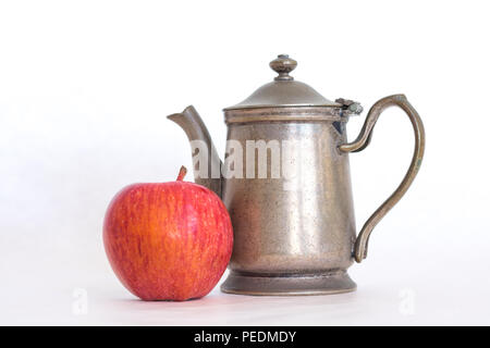 Retro Zinn Antik Silber Farbe altmodische Teekanne mit ein homegrown Red Delicious apple Neben es auf einem weißen Hintergrund, gesunden Lebensstil in der Stockfoto