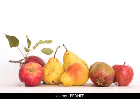 Drei reife, gelbe Hautfarbe Birnen rote Äpfel und ein Granatapfel, frische organische schöne Studio shot mit Stängel und Blätter Stockfoto