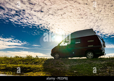 Estland - August 2018: VW Transporter T4 auf Ostsee mit Sonnenuntergang im Hintergrund und blauen Himmel mit Wolken. Der Volkswagen Transporter (T4) ist ein Van pr Stockfoto