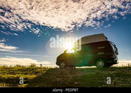 Estland - August 2018: VW Transporter T4 auf Ostsee mit Sonnenuntergang im Hintergrund und blauen Himmel mit Wolken. Der Volkswagen Transporter (T4) ist ein Van pr Stockfoto