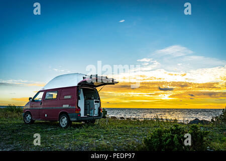 Estland - August 2018: VW Transporter T4 auf Ostsee mit Sonnenuntergang im Hintergrund und blauen Himmel mit Wolken. Der Volkswagen Transporter (T4) ist ein Van pr Stockfoto