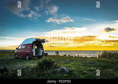 Estland - August 2018: VW Transporter T4 auf Ostsee mit Sonnenuntergang im Hintergrund und blauen Himmel mit Wolken. Der Volkswagen Transporter (T4) ist ein Van pr Stockfoto