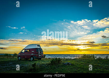 Estland - August 2018: VW Transporter T4 auf Ostsee mit Sonnenuntergang im Hintergrund und blauen Himmel mit Wolken. Der Volkswagen Transporter (T4) ist ein Van pr Stockfoto