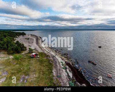 Estland - August 2018: VW Transporter T4 auf Ostsee mit Sonnenuntergang im Hintergrund und blauen Himmel mit Wolken. Im Vordergrund, Camping Ausrüstung ist eingestellt Stockfoto