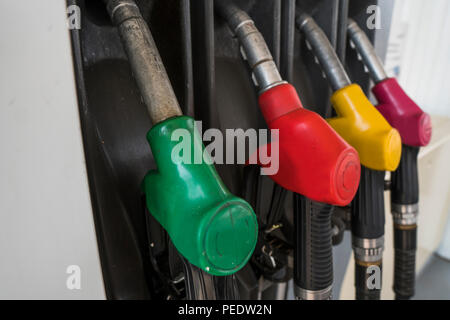 In der Nähe von verschmutzten Kraftstoff Düse in Öl Spender mit Benzin und Diesel in Service Tankstelle. Muster Benzin pumpe gun Füllung Grün Rot Gelb Pink farbenfroher Stil. Energie Stockfoto