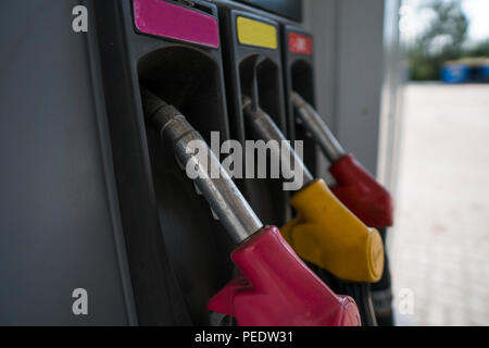 In der Nähe von verschmutzten Kraftstoff Düse in Öl Spender mit Benzin und Diesel in Service Tankstelle. Muster Benzin pumpe gun Füllung Grün Rot Gelb Pink farbenfroher Stil. Energie Stockfoto