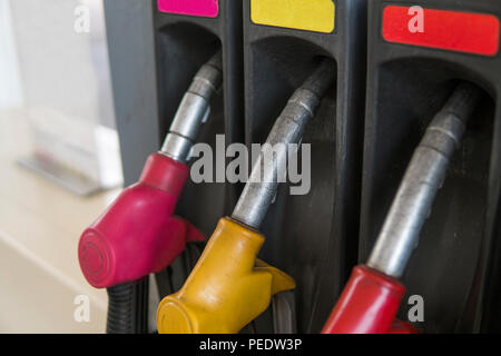 In der Nähe von verschmutzten Kraftstoff Düse in Öl Spender mit Benzin und Diesel in Service Tankstelle. Muster Benzin pumpe gun Füllung Grün Rot Gelb Pink farbenfroher Stil. Energie Stockfoto