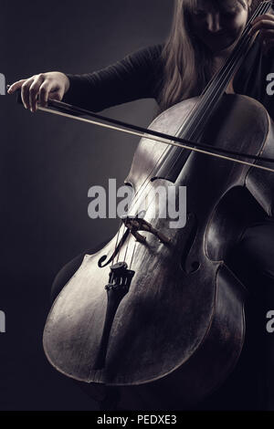 Nahaufnahme der Cellist spielt klassische Musik am Cello auf schwarzem Hintergrund Stockfoto