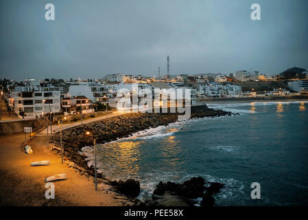 Am Strand und am Abend Leuchten in Punta Hermosa Surfer Stadt, gesehen von "La Isla" (Rocky Island mit dem Land verbunden). Provinz Lima, Peru. Jun 2018 Stockfoto