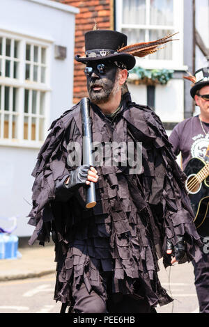 Traditionelle englische Volkstänzer, Wolfs Kopf Morris Dance Seite, in Schwarz tatter Jacken, Tanzen in der Straße am Sandwich Folk und Ale-Festival. Stockfoto