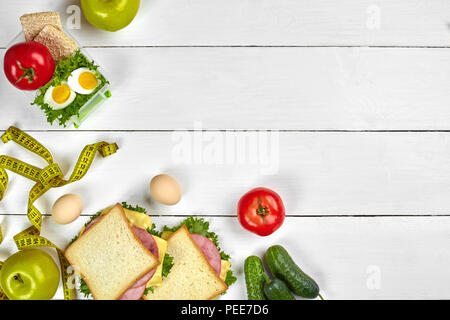 Mittagessen. Sandwiches und frischem Gemüse, eine Flasche Wasser und grüner Apfel auf hölzernen Tisch. Gesunde Ernährung Konzept. Ansicht von oben Stockfoto