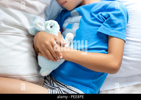 Kleinen Jungen schlafen im Bett hielt seine Bunny robbit. Stockfoto