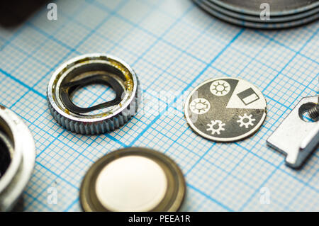 Teile sind vollständig demontiert alten retro Film SLR Kamera auf Millimeterpapier, close-up Stockfoto