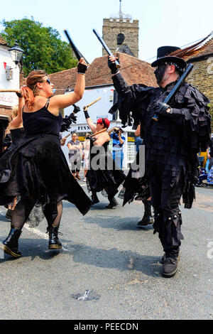 Traditionelle englische Volkstänzer, Wolfs Kopf und Vixen Morris Dance Seite, in Schwarz, Tanzen in der Straße am Sandwich Folk und Ale-Festival. Stockfoto