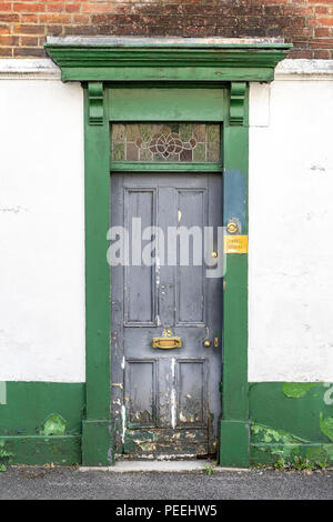 Alt und schäbig grau Tür mit Grün umgeben Stockfoto