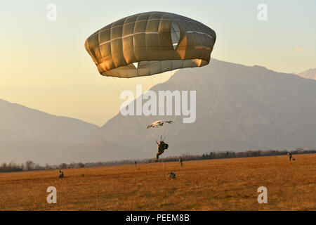 Die US-Armee Fallschirmjäger auf die 173Rd Airborne Brigade zugeordnet bereitet auf Julia Drop Zone in Pordenone, Italien, Jan. 20, 2016 zu landen, während der Betrieb von einem US Air Force 86th Air Wing Hercules C-130 Flugzeugen. Die 173Rd Airborne Brigade ist der US-Armee Contingency Response Force in Europa, die in der Projektion bereit Kräfte überall in den USA in Europa, Afrika oder Verantwortungsbereich Zentrale Befehle' innerhalb von 18 Stunden. (U.S. Armee Foto von visuellen Informationen Spezialist Davide Dalla Massara/Freigegeben) Stockfoto