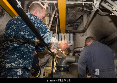 160118-N-GR 361-012 NAVAL SUPPORT ACTIVITY BAHRAIN (Jan. 18, 2016) befehlshabenden Offizier, Kapitän Sean Bailey (links) und Chief Engineer Lt.Cmdr. Ronald Viggiani (rechts) zeigen Generalmajor Carl E. Mundy III, Kommandeur der Task Force (CTF) 51 von der Hauptmaschine während einer Tour an Bord der amphibious Transport dock Schiff USS Arlington LPD (24). Arlington ist Teil der Kearsarge Amphibious Ready Group (ARG) und, mit dem begonnen 26 Marine Expeditionary Unit (MEU), ist zur Unterstützung der Maritime Security Operations und Theater Sicherheit Zusammenarbeit in den USA 5 Flotte Bereich der Operationen eingesetzt. (U.S. Marine Stockfoto