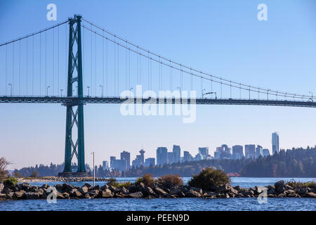 Lions Gate Suspension Brücke über Burrard Inlet Frames der Innenstadt von Vancouver, BC mit den Bäumen und dem Wald von Stanley Park in der Mitte. Stockfoto