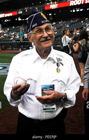 Philip Säcke, ein lila Herzen Empfänger, spricht sie mit einem Mitarbeiter der Seattle Mariners' vor dem Werfen den zeremoniellen ersten Pitch während des Teams Purple Heart Nacht im Safeco Field, Seattle, 10.08.2015. Säcke erhielt seine Purple Heart von der Artillerie die Schlacht von Heartbreak Ridge 1951 während des Korea Krieges. (U.S. Armee Foto von Sgt. 1. Klasse Andrew Veranda, 28 Public Affairs Abteilung) Stockfoto