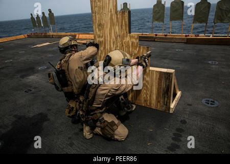 Indischer Ozean (4. August 2015) US-Marines mit maritimen Raid-Kraft das Feuer des 15 Marine Expeditionary Unit bei Ziele hinter einer Barrikade während ein Deck schießen an Bord der Amphibisches Schiff USS Essex (LHD2). Diesen Marinen praktiziert Rangieren als Buddy Teams zu verschiedenen Quellen der Deckung ihre Treffsicherheit zu verbessern. Die 15. MEU ist auf der Essex Amphibious Ready Gruppe begonnen und bereitgestellt, um die regionale Sicherheit in den USA 5 Flotte Bereich der Betrieb aufrecht zu erhalten. (U.S. Marine Corps Foto von Cpl. Anna Albrecht/Freigegeben) Stockfoto