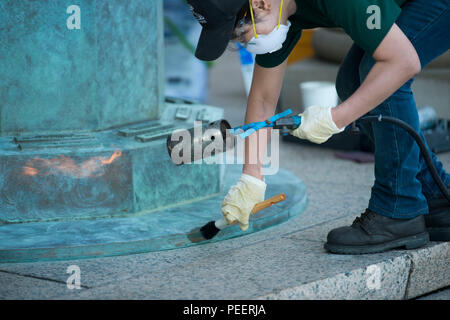 Sachika Iwata, aus New York, arbeitet auf der Basis von Greg Wyatt's "Preis der Freiheit" etwas außerhalb von Arlington National Cemetery's Welcome Center, 12.08.2015, in Arlington, Virginia. Die Skulptur 25. Mai 2003 eingeweiht wurde, Memorial Day, und wird jährlich gewartet. (U.S. Armee Foto von Rachel Larue/freigegeben) Stockfoto