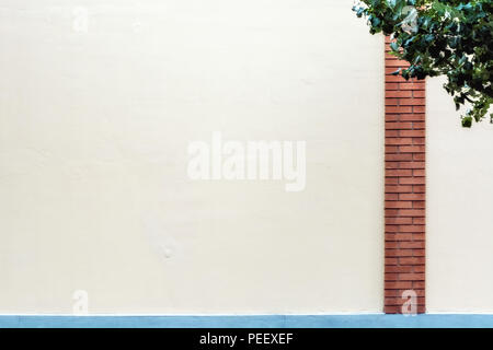 Die Mauer ist blass rosa mit einer Spalte aus rotem Backstein und einem blauen Rahmen, für den Einsatz als Hintergrund. Stockfoto