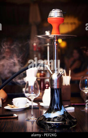 Shisha in einer Wolke von Rauch auf einem Tisch in einem Nachtclub. Stockfoto