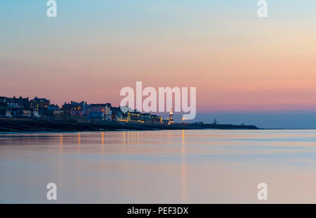 Herne Bay Seafront und Uhrturm mit einem bunten Dämmerung Himmel im Hintergrund beleuchtet. Stockfoto