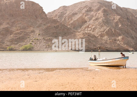 Yiti Muscat Oman Strand an einem sonnigen Tag mit dem trüben Wetter in Bergen im Hintergrund Stockfoto